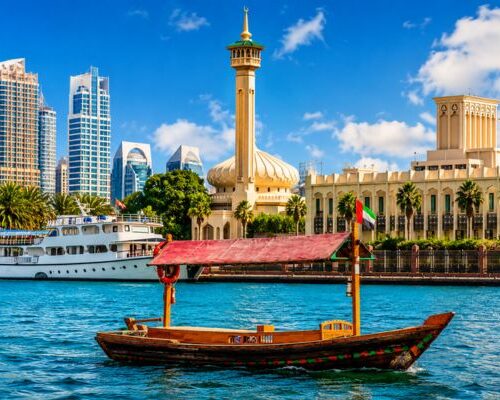 Traditional wooden abra ride on Dubai Water Canal with Burj Khalifa views
