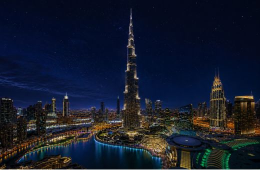 Burj Khalifa towering over Downtown Dubai seen from a Dubai Water Canal cruise at night